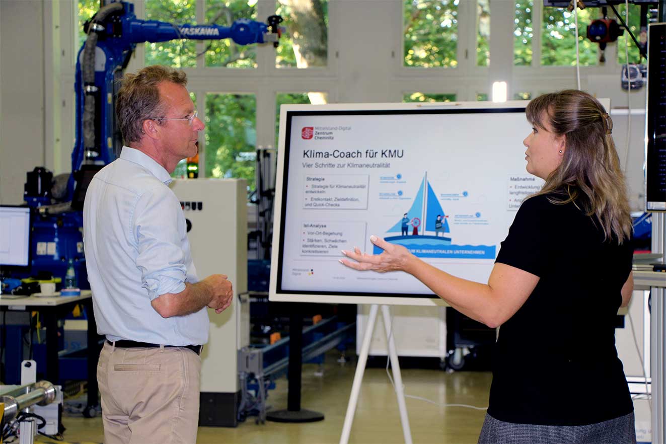 Eine Mitarbeiterin der Professur Fabrikplanung und Intralogistik erlaeutert eine Modellanwendung in der Experimentier- und Digitalfabrik der TU Chemnitz